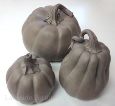 three gray ceramic pumpkins sitting next to each other