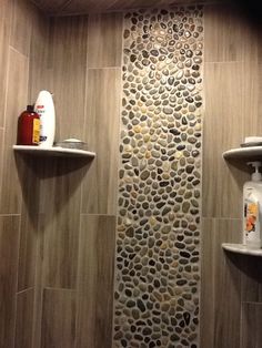 a bathroom with stone walls and shelves on the wall, along with toiletries in the corner