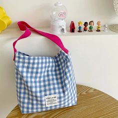 a blue and white bag sitting on top of a wooden table next to toy figurines