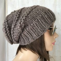 This is a handmade knit slouchy womens hat. The yarn is a wool blend which contains 20% wool-80% acrylic. It's a perfect for winter season. Sizes: One size fits average teen or adult head size of 22" to 23" (50.5 cm to 58 cm). Fiber Content: 80% acrylic, 20% Wool Characteristics: Chunky, very soft, warm and cozy. Care Instructions: Hand wash, dry flat. Every item from srithehat is handmade and knit or crocheted to order, unless otherwise stated in title of the item as "ready to ship". Production time may vary, please check the SHIPPING & POLICIES tab for accurate processing times. If you need an item promptly, please contact us so that we can make arrangements. While every effort is made to accurately represent the true colors of the yarns used in our work, your monitor settings may affect Crochet Brown, Oversized Hat, Cable Hat, Chunky Knit Hat, Handmade Knitwear, Womens Hat, Slouch Beanie, Handmade Knit, Pattern Store