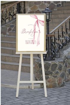 a sign with a pink ribbon on it in front of some stone steps and stairs