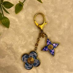 a blue and purple flower shaped keychain sitting on top of a white surface