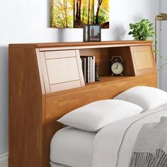 a bed with white pillows and a wooden headboard