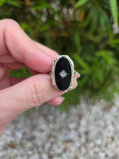 Antique Art Deco 14k white gold black onyx diamond pinkie ring, size 2. Measures 7/8" x 5/8" and weighs 4.1 grams. Beautiful little bow garlands on the shoulders of the band, 2.2mm diamond set in the center of the black onyx. The onyx measures 3/4" x 3/8". Unmarked (previously sized as a pinky ring), tested as 14k gold content/purity. In excellent well cared for condition, circa 1920s.  On the fence about something you see on our web site today? We welcome you to read our reviews! https://www.etsy.com/shop/SundayandSunday/reviews OUR RETURN/REFUND POLICY: If you wish to return an item, you MUST notify us within the allowable THREE (3) DAY INSPECTION PERIOD after you receive it. We will refer to the USPS delivery confirmation (tracking) date that was provided to you at the time of your purc Oval White Gold Jewelry With Black Enamel, Classic White Gold Jewelry With Black Enamel, 14k White Gold Jewelry With Black Diamonds, Formal Black Enamel Fine Jewelry Rings, Oval Black Enamel Diamond Jewelry, White Gold Diamond Jewelry With Black Enamel, Oval Diamond Jewelry With Black Enamel, Oval Onyx Jewelry For Anniversary, Antique Black Rings With Rose Cut Diamonds