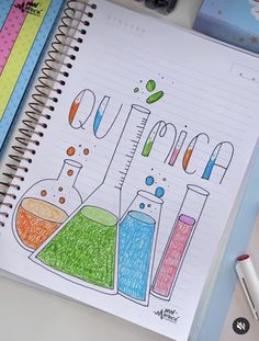 an open notebook with colored pencils on top of it next to markers and pens