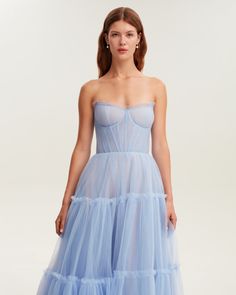 Dreamy tulle dress in light blue color with a light ruffled tulle maxi skirt. This dress has a heart-shaped boned semi-transparent bodice with built-in cups and a corset back, which makes the silhouette fitted and elegant. The A-line maxi skirt is made from multiple layers of delicate tulle that emphasize the hourglass silhouette. The waistline is adorned with a silver belt with Milla’s signature.This dress comes with straps, adding an elegant touch. Details: Material: Tulle Fabric composition: Wedding Midi Dress With Ruffled Skirt, Midi Wedding Dress With Ruffled Skirt, Midi Length Wedding Dress With Ruffled Skirt, Blue Floor-length Evening Dress With Tulle Skirt, Blue Tulle Evening Dress With Tulle Skirt, Prom Dress With Pleated Bodice In Tulle, Tulle Dress With Pleated Bodice For Prom Season, Blue Tulle Dress With Boned Bodice, Gala Tulle Dress With Lined Bodice