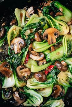 stir fry with mushrooms and broccoli in a black wok on the stove