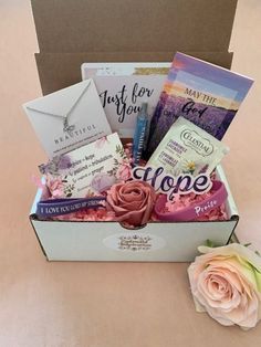 an open box with some cards and flowers