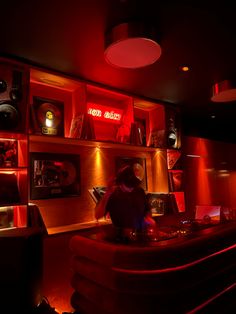 a room filled with lots of red lights and shelves full of musical equipment on top of it