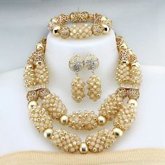 Enhance your bridal look with this classic Nigerian Wedding Bridal Jewelry. The African crystal beads jewelry set adds a touch of elegance and cultural significance to your wedding ensemble, creating a timeless and beautiful look. Bridal Gold Pearl Necklace With Round Beads, Gold Bridal Sets With Hand Set Crystals, Traditional Gold Bridal Necklace With Large Beads, Pearl White Jewelry With Gold Round Beads, Gold Beaded Bridal Necklace, Gold Beaded Round Bridal Necklace, Gold Round Beaded Bridal Necklace, Elegant Gold Bridal Sets For Traditional Ceremonies, Gold Beaded Necklaces For Traditional Ceremonies