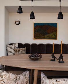 a dining room table with two candles on it