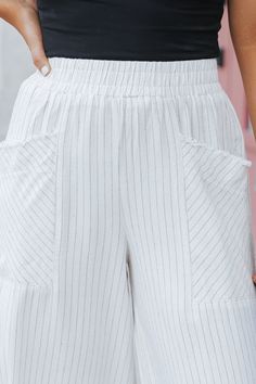 These linen wide leg pants are perfect for everyday wear and beach vacations! Expertly crafted with a smocked waistband and front pockets, these Oatmeal Striped Linen Wide Leg Pants offer both style and functionality. The frayed detail adds a touch of edginess, while the blend of 55% linen and 45% rayon ensures comfort and durability. Perfect for any occasion! Style with a basic tank top, comfy slide sandals, and a woven crossbody bag for a chic vacay-ready outfit! High-waisted Pants With Pockets For Beach Season, Vacation Wide Leg Pants With Side Pockets, Linen Bottoms With Pockets For Beach Season, Beach Season Linen Bottoms With Pockets, Summer Loungewear Pants With Pockets, Cotton Wide Leg Pants With Pull-on Style For Vacation, Cotton Wide Leg Pull-on Pants For Vacation, Cotton Pull-on Wide Leg Pants For Vacation, Summer High Waist Wide Leg Pants With Side Pockets