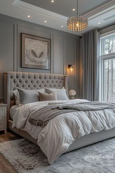 a large bed sitting next to a window with a chandelier hanging above it