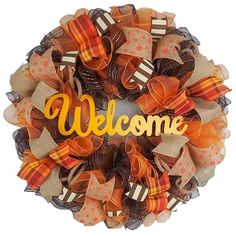 a welcome wreath with orange and brown bows on it's front door for fall