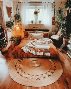 a bedroom with wooden floors and lots of plants on the wall above the bed, along with a round rug