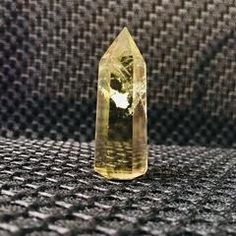 a large yellow diamond sitting on top of a black cloth covered table next to a wall