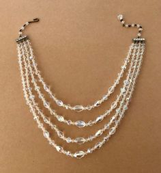 "SALE Vintage 1950s Four Strand Graduated Clear AB Faceted Crystal Necklace With Adjustable Length Hook & Beaded Chain Clasp With Spacer Bars Was $69.00 Now $64.00! A classic piece of costume jewelry made circa the 1950's. Four graduated strands of faceted clear AB crystals. The AB means aurora borealis which is a rainbow effect of color. The maximum length is approximately 16\" end to end measuring the shortest strand and the longest length for the clasp. The minimum is roughly 14 1/4\". Th Vintage Wedding Jewelry With Beaded Chain, Vintage Multi-strand Beaded Necklace With Polished Beads, Vintage Crystal Necklaces For Party, Vintage Crystal Necklaces For Formal Occasions, Vintage Crystal Necklace For Formal Occasions, Vintage Single Strand Crystal Necklace With Round Beads, Vintage Multi-strand Necklaces With Polished Beads, Vintage Multi-strand Beaded Chain Necklaces, Vintage Polished Beads Jewelry For Wedding