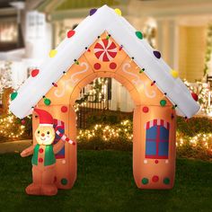 an inflatable christmas house with lights and decorations on the front lawn is shown