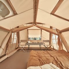 a bed sitting inside of a tent next to a window