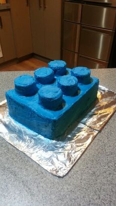 there is a cake made to look like legos on the counter top with blue icing