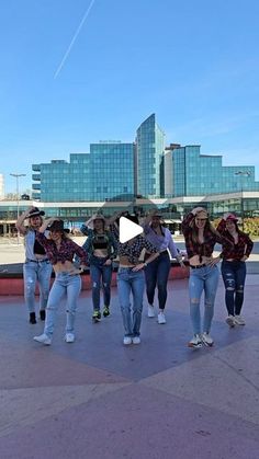 a group of young women standing next to each other on top of a cement ground