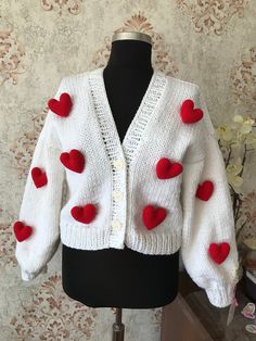 a white sweater with red hearts on it