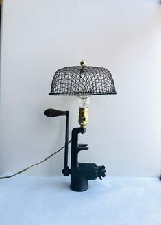 a lamp that is sitting on top of a white table next to a black faucet