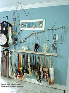 there is a rack full of purses and handbags hanging on the wall in this room