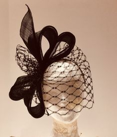 Eye catching large "bow" made in quality black pinok pok material with veiling.  It's held securely in place by a hand made head band of cotton covered millinery wire which can be gently bent/shaped to your head shape and is, therefore, both secure and comfortable to wear.  The band is dyed to blend with the colour of your hair.   As with all my pieces made with care using traditional millinery techniques and materials. Postage & packaging fee includes elegant hat box. As each hat is made indivi Pill Box Hat With Veil, Fascinator Hats Wedding Guest, Black Birdcage Veils, Unique Fascinators, Fascinator Hats Outfit, Evening Hat, Fascinator Hats Diy, Hat With Veil, Elegant Hat