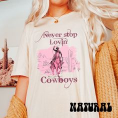 "This Valentines Day Shirt is a fun and stylish option for women who love western fashion and graphic tees. This shirt features a western cowboy design and the phrase \"Never Stop Lovin' Cowboys\" in a retro font, making it perfect for fans of western and Valentine's Day themes. This shirt is soft, comfortable, and easy to wear all day long. Whether you're looking for a unique outfit for a Valentine's Day party or simply want to show off your love for all things western, this shirt is a great ch Letter Print T-shirt For Rodeo, Cowboy Valentines, Cowboy Design, Disco Cowgirl, Unique Outfit, Retro Valentines, Retro Font, Cow Boy, Valentines Day Shirts