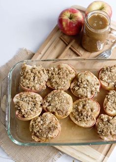 apple pie muffins in a glass baking dish on a cutting board next to an apple