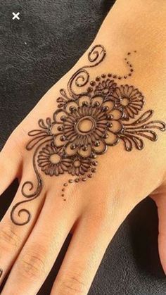 a woman's hand with a henna tattoo on it