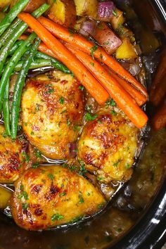 a crock pot filled with chicken, potatoes and green beans next to carrots