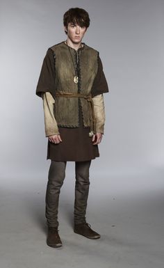 a young man dressed in medieval clothing posing for the camera with his hands on his hips