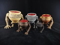 four different sized vases sitting next to each other on a black cloth covered surface