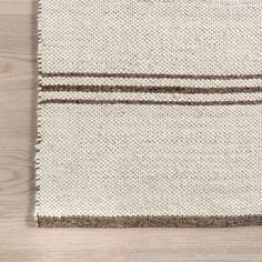 a white and brown rug on top of a wooden floor