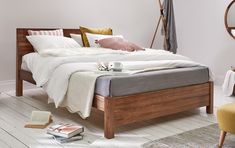 a bed sitting in a bedroom next to a wooden headboard on top of a hard wood floor