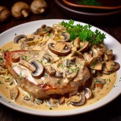 a white plate topped with meat covered in mushroom sauce