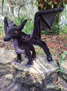 a black dragon statue sitting on top of a rock