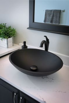 a bathroom sink sitting on top of a white counter next to a black faucet