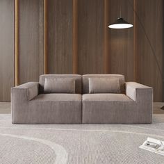 a couch sitting on top of a carpet covered floor next to a wall with wooden paneling