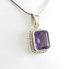 Large emerald cut 10x12mm genuine amethyst gemstone is set in sterling silver in Nepal. Handmade blue topaz pendant is 1 1/8 inches long and 5/8 inch wide and is sold separate from the snake chain shown. To clean pendant: simply use a jewelry polishing cloth to brighten the silver. Style Number: 7732 Metal: 925 Sterling Silver Gemstone: Genuine Amethyst Dimensions: 1 1/8 inches long and 5/8 inch wide Handmade in Nepal Formal Sterling Silver Rectangular Pendant, Sterling Silver Faceted Square Pendant Jewelry, Faceted Sterling Silver Square Pendant Jewelry, Classic Amethyst Gemstone Jewelry, Square Pendant Gemstone Fine Jewelry, Fine Jewelry With Square Gemstone Pendant, Classic Amethyst Pendant Jewelry, Fine Jewelry With Rectangular Gemstone Accents, Fine Jewelry With Gemstone Accents Rectangular Shape