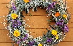 a wreath made out of dried flowers on a wooden wall