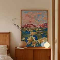 a painting is hanging on the wall above a bed