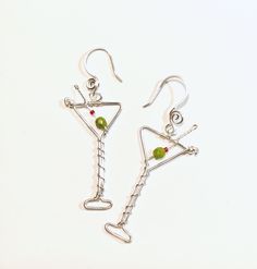 "Fun martini glass earrings ..now with improved more realistic beads for the olive...I used 4mm green faceted oval shape beads.  These also have a better earhook placement in the center so they hang straight not tilted.    The silver wire is 18 gauge silver plated non tarnish.  Drop length is 2.25\".  Your choice of silver or goldplate too. *If ordered as a gift it will come in a box as shown.  Just added a new variation of Espresso martinis! ..with brown bronzite beads and white faux pearls beads.  Now available you can order the necklace.. pendant martini with chain.   Chain is 20\" stainless steel.  Gold chain is goldplate. * I also have many other beverage party earrings too ! : Champagne : https://www.etsy.com/listing/1380883157   Margarita: https://www.etsy.com/listing/1557159350/ Wi Green Wire Wrapped Jewelry For Party, Party Glass Jewelry Wire Wrapped, Party Wire Wrapped Glass Jewelry, Wire Wrapped Czech Glass Jewelry For Party, Wire Wrapped Silver Plated Ring For Party, Silver Wire-wrapped Earrings For Party, Silver Wire Wrapped Earrings For Party, Silver Glass Earrings For Party, Martini Earrings