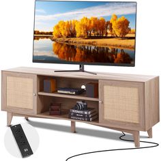 a flat screen tv sitting on top of a wooden entertainment center next to a remote control