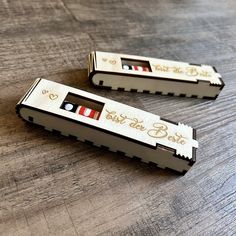 two wooden combs sitting on top of a table next to each other with writing on them