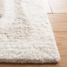 a white rug on the floor with wooden floors