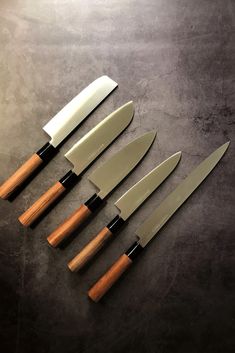 five knives are lined up on a table