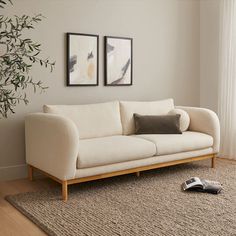 a living room with two framed pictures on the wall and a couch in front of it